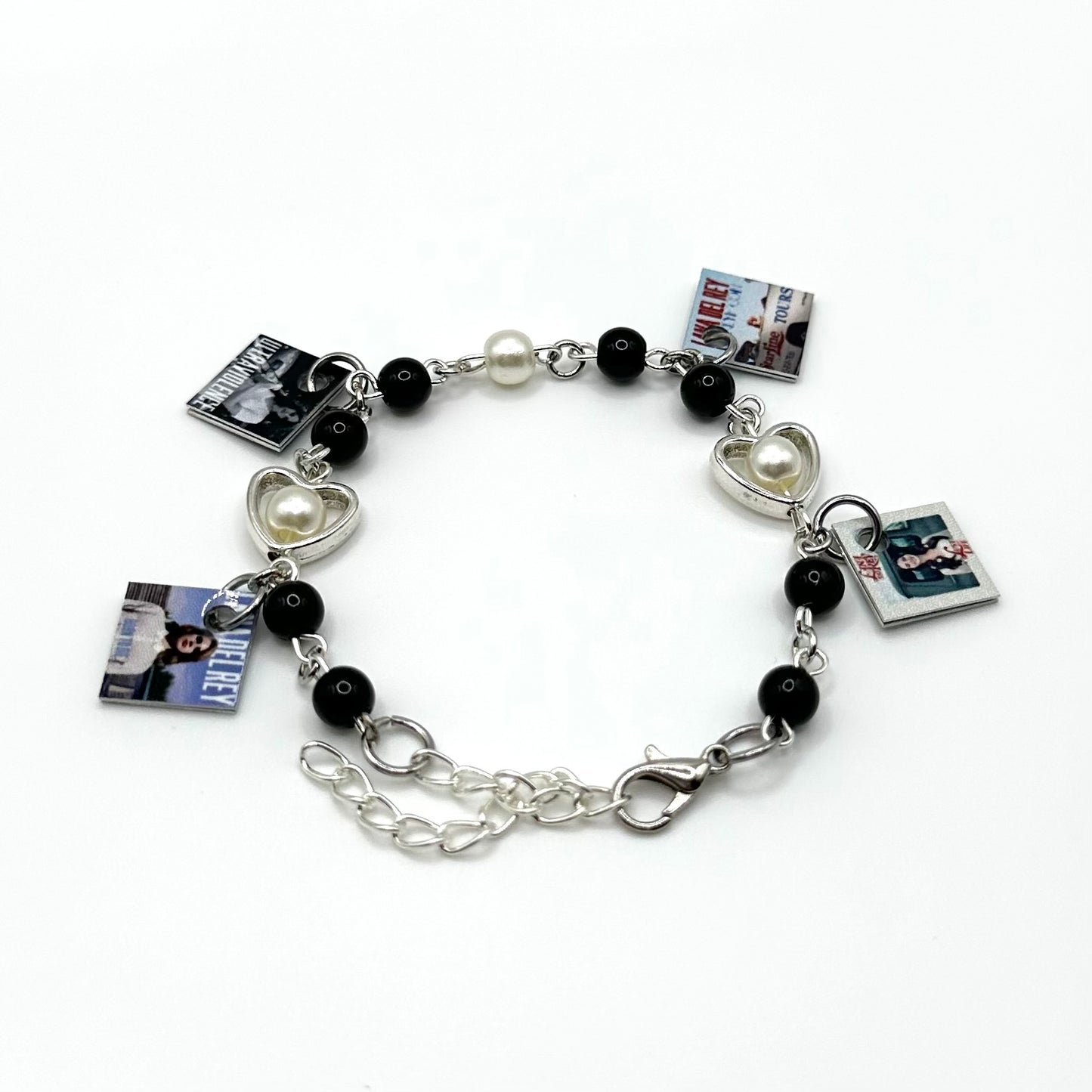 A charm bracelet with miniature (half inch) metal Lana Del Rey albums and lobster claw clasp closure.