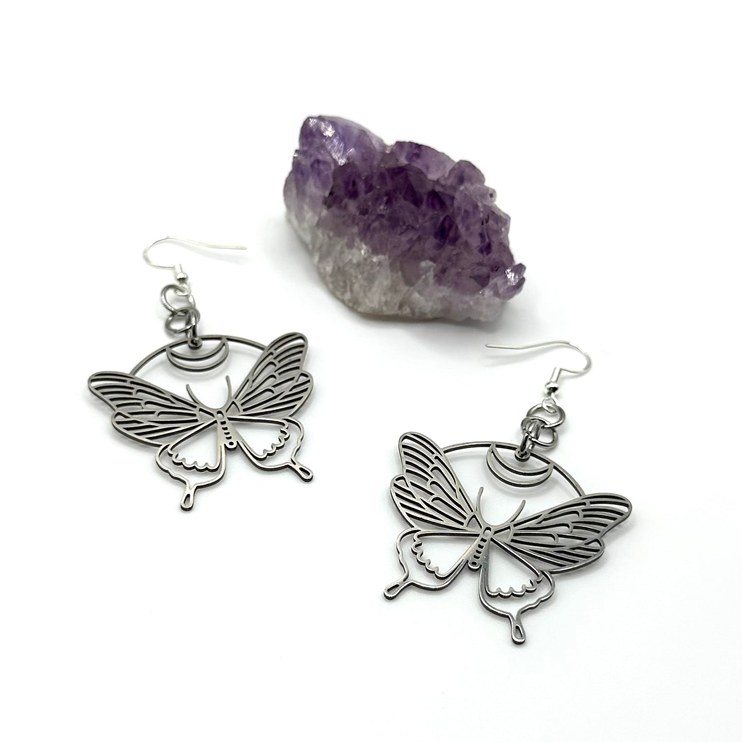 A pair of stainless steel butterfly/moth earrings with a hypoallergenic sterling silver ear wire closure.