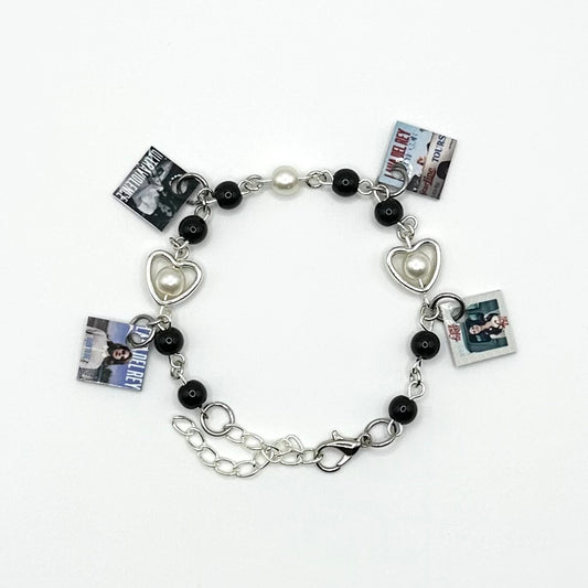 A charm bracelet with miniature (half inch) metal Lana Del Rey albums and lobster claw clasp closure.
