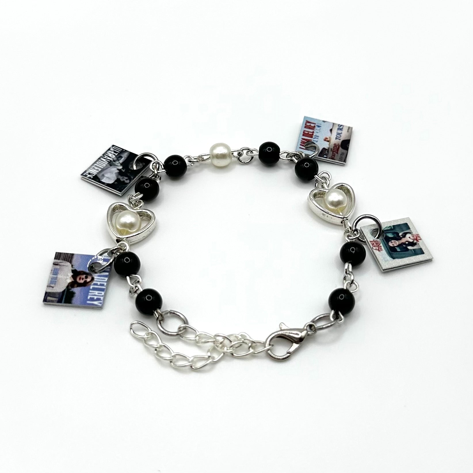 A charm bracelet with miniature (half inch) metal Lana Del Rey albums and lobster claw clasp closure.