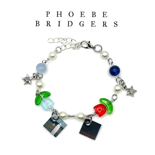 A charm bracelet with miniature (half inch) metal Phoebe Bridgers albums and lobster claw clasp closure.