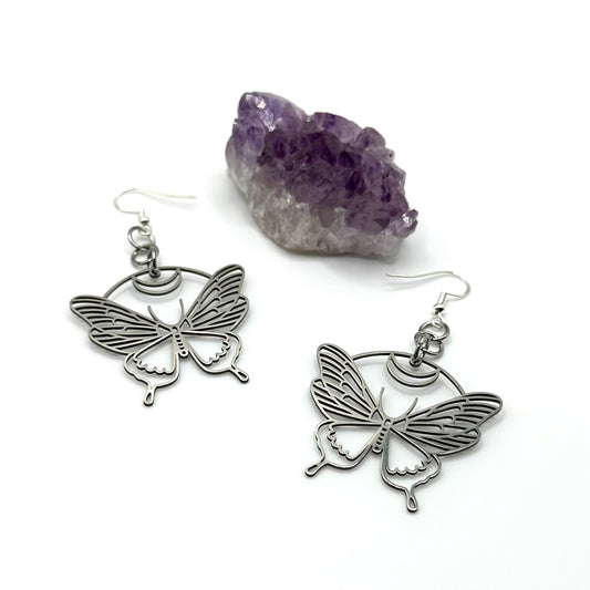 A pair of stainless steel butterfly/moth earrings with a hypoallergenic sterling silver ear wire closure.