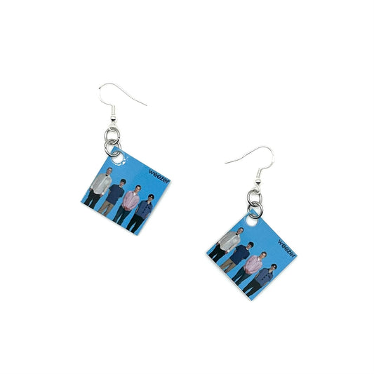 A pair of square earrings with an image of Weezer's Blue Album, attached to hypoallergenic sterling silver ear wire closure.